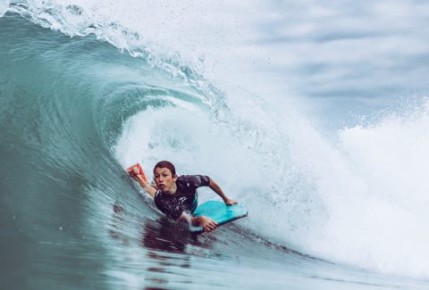 Joven surfea una ola