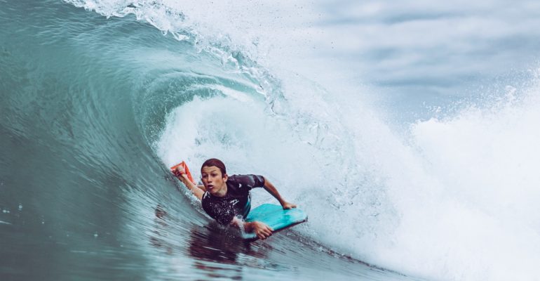 Joven surfea una ola